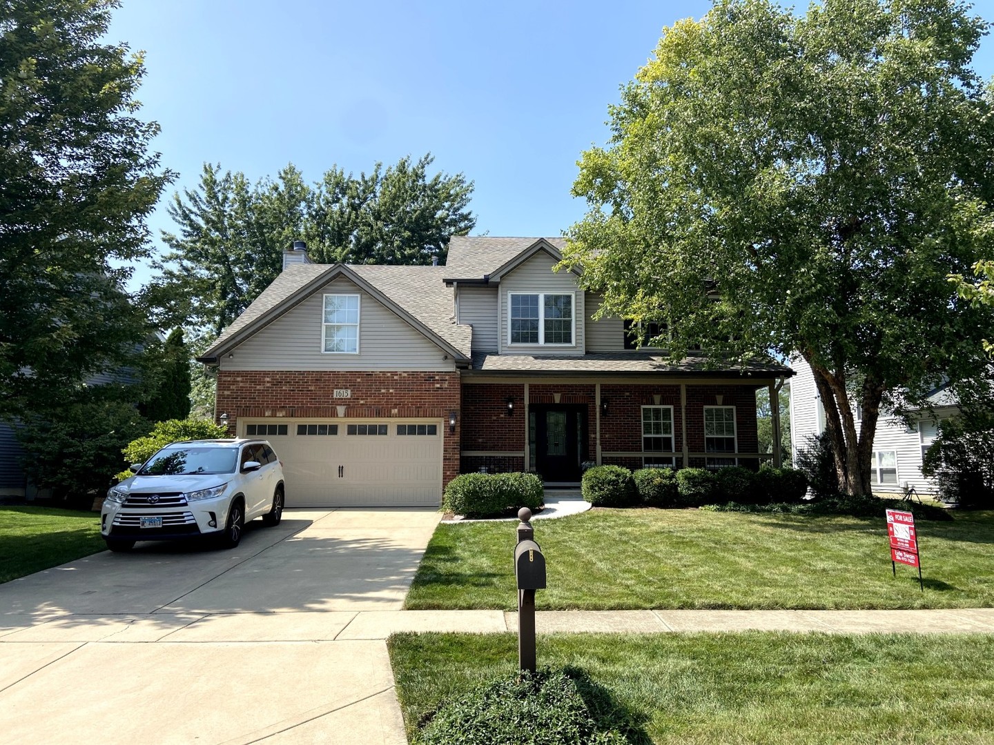 a front view of a house with a yard and potted plants