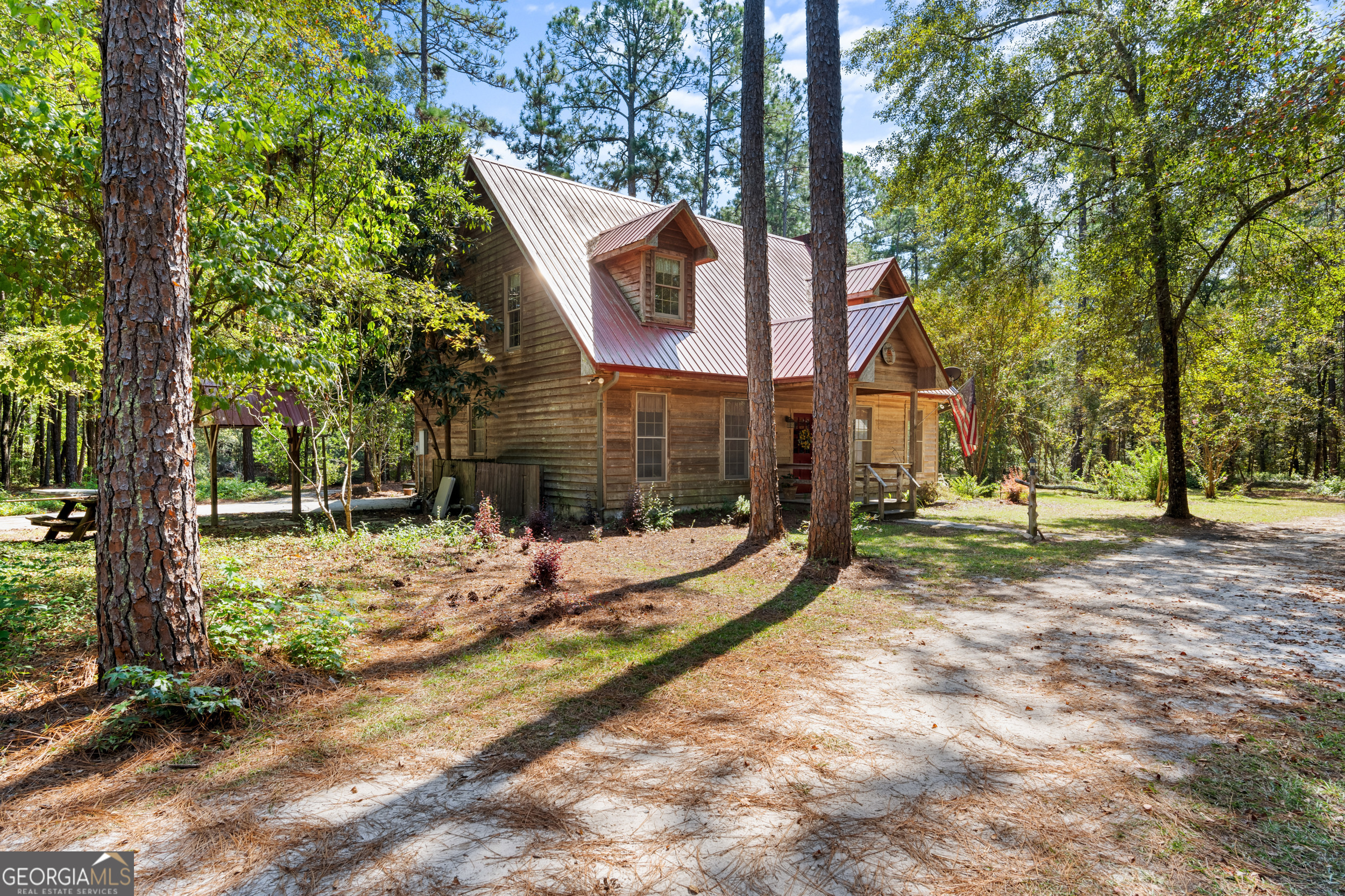 a view of a house with a yard covered in the forest