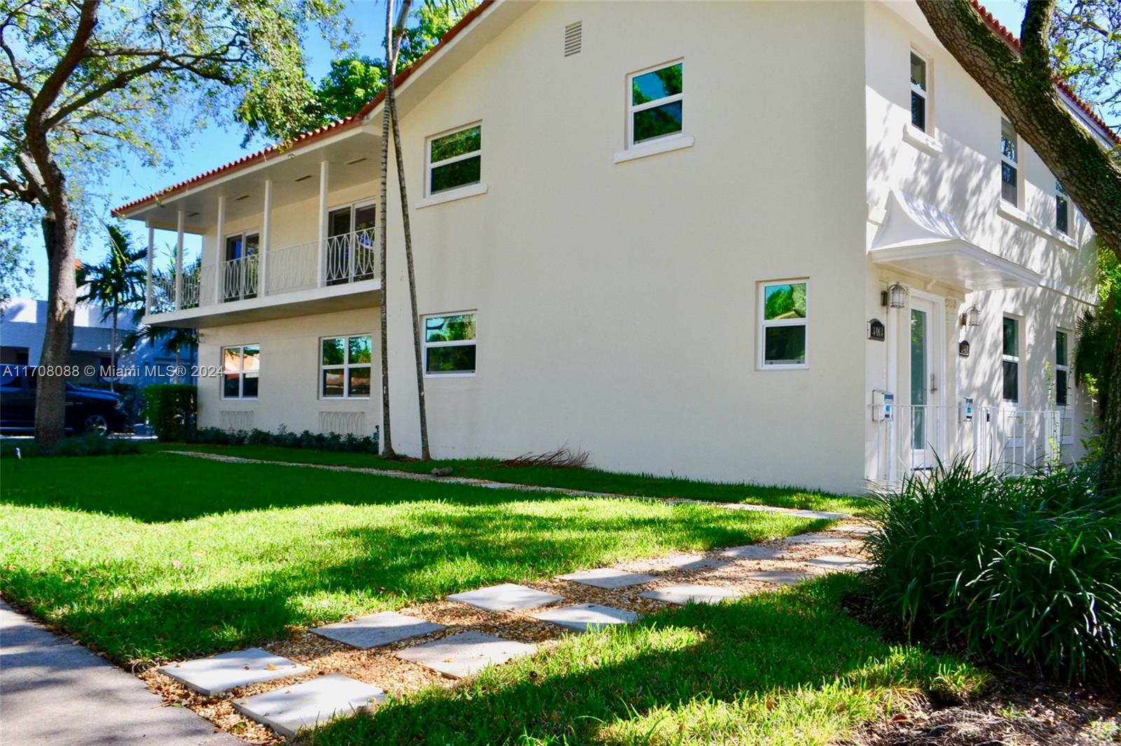 a view of a white house with a yard and plants