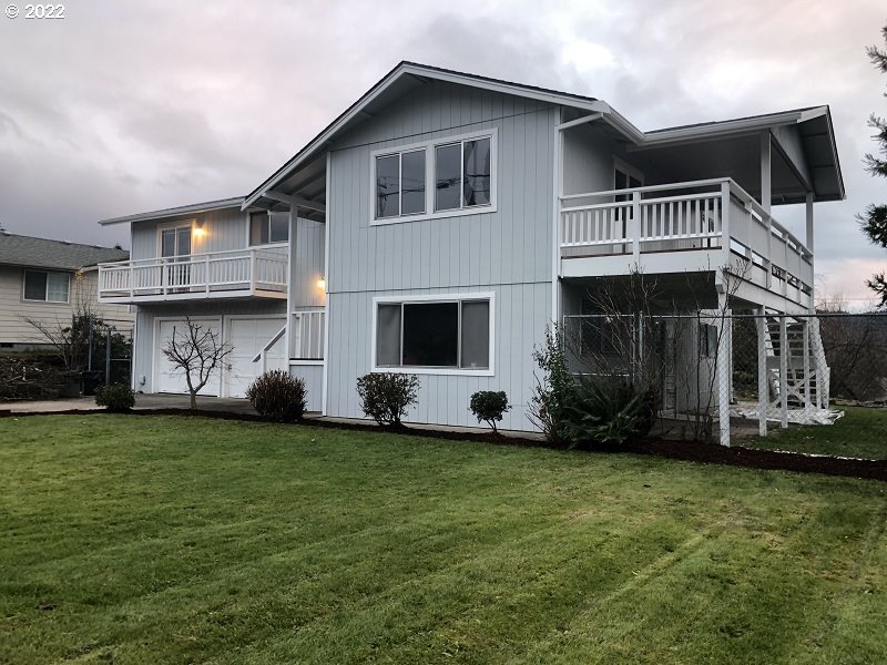 a view of a house with a yard and sitting area