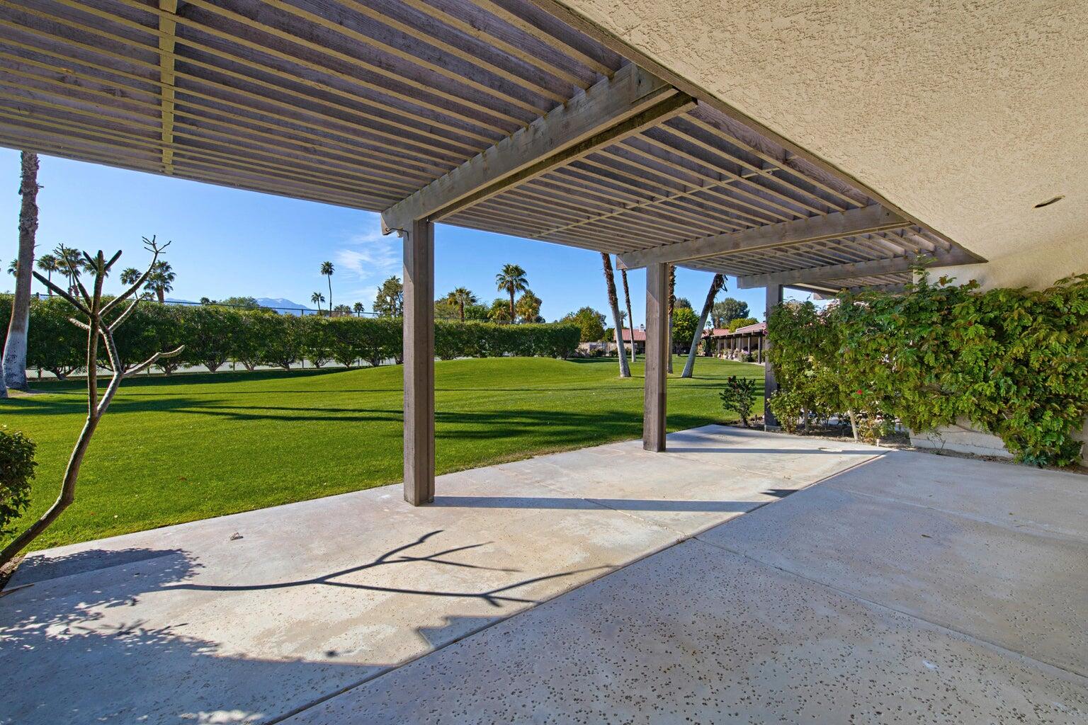 a patio with a table and chairs under an umbrella