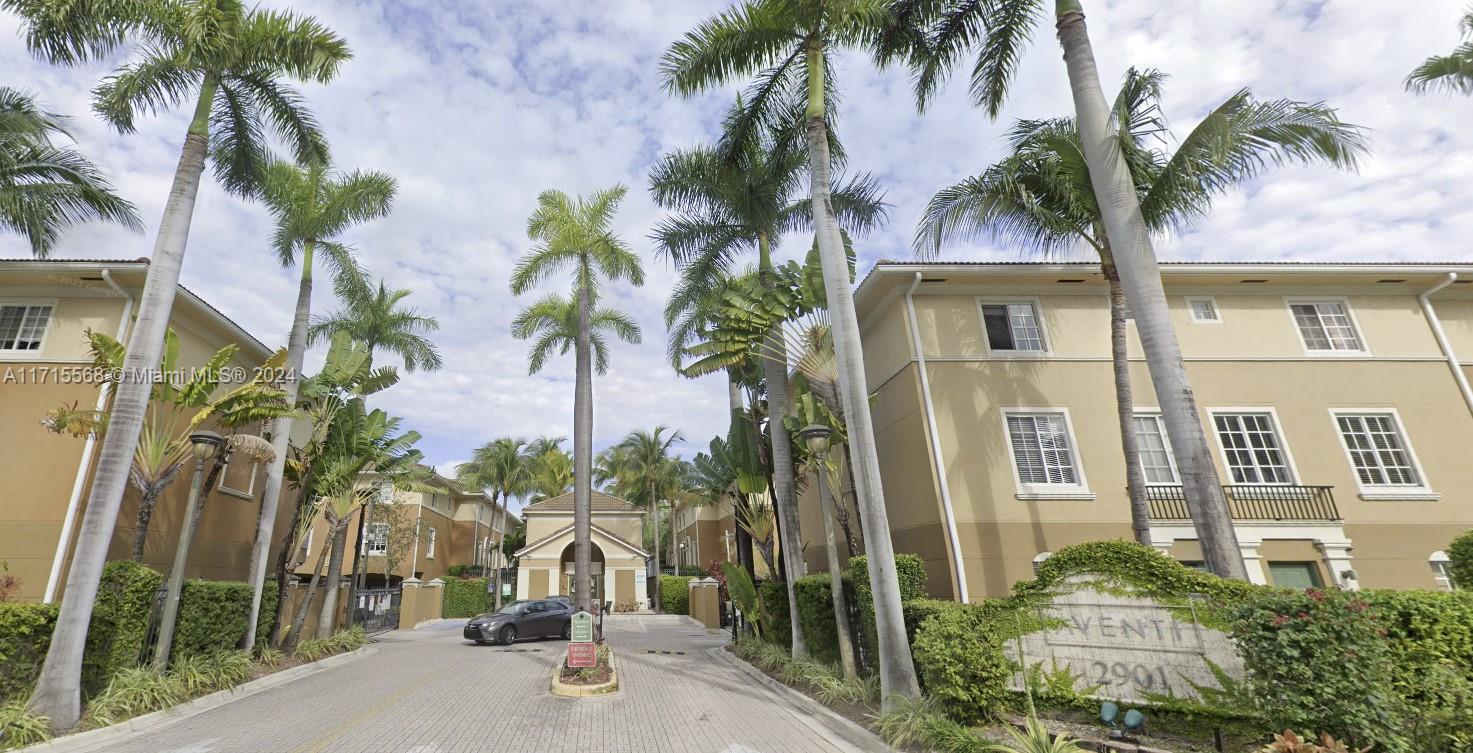 a view of a house with a palm tree and a yard