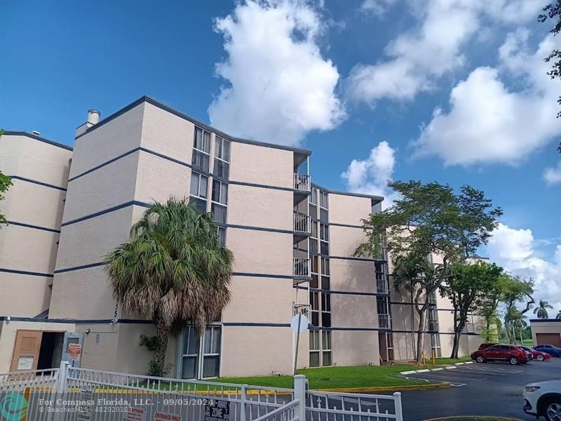 a view of a tall building next to a yard