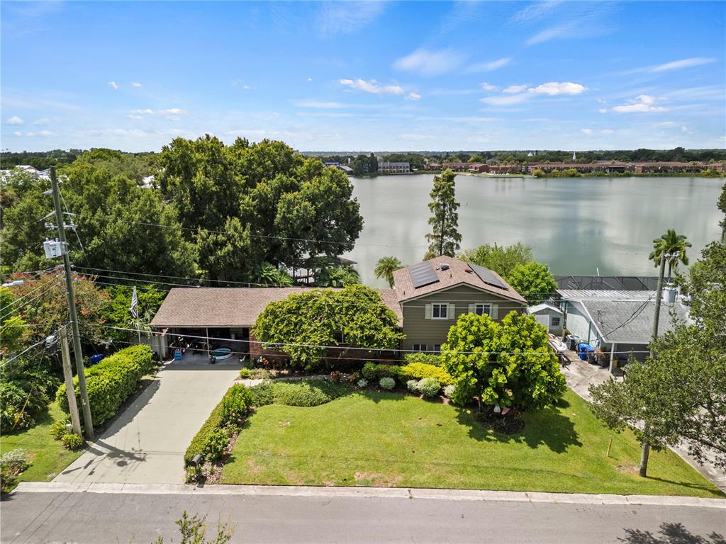 an aerial view of a house with a garden and lake view