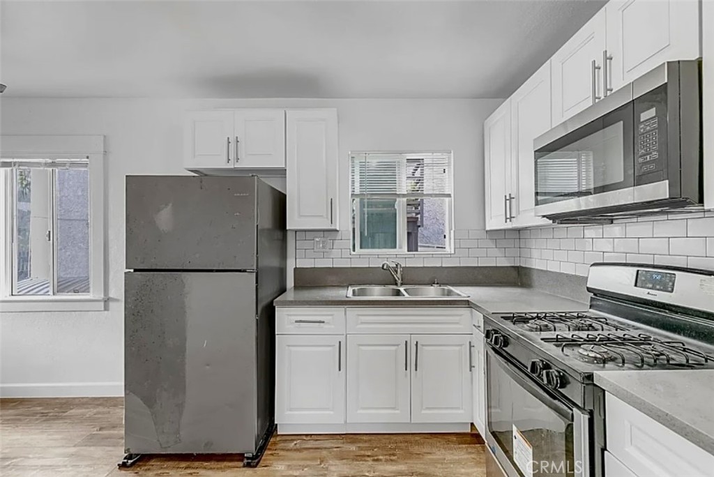 a kitchen with a stove a refrigerator and a stove top oven