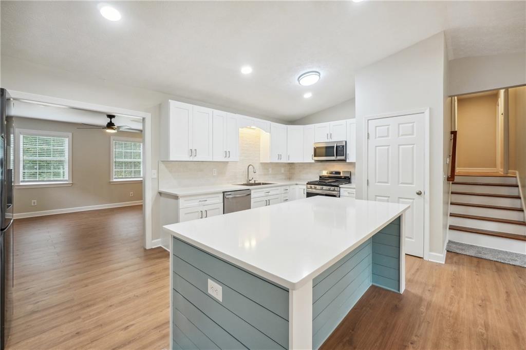 a kitchen with granite countertop a stove top oven and cabinets