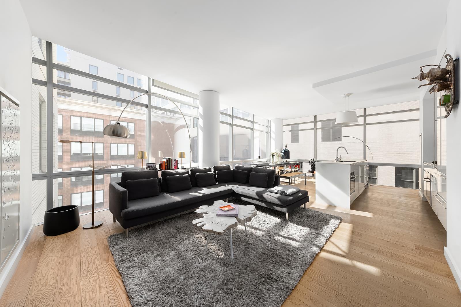 a living room with furniture large window and wooden floor