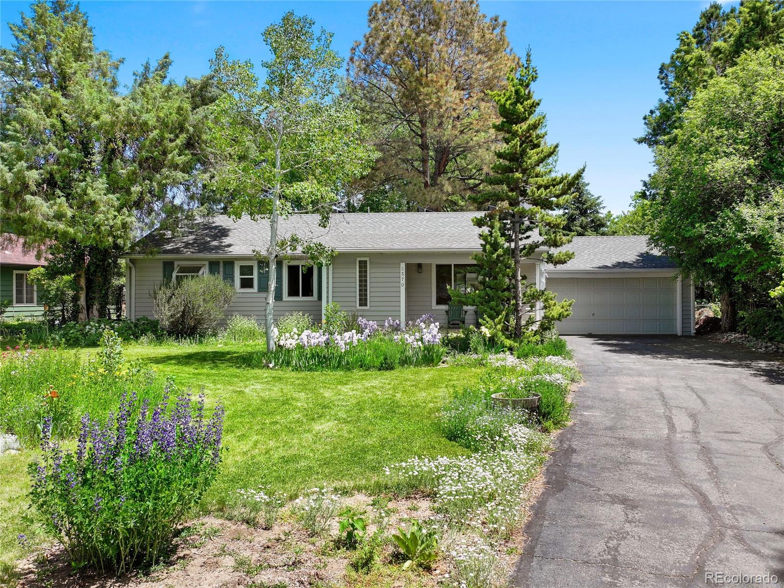 a front view of a house with a yard and potted plants