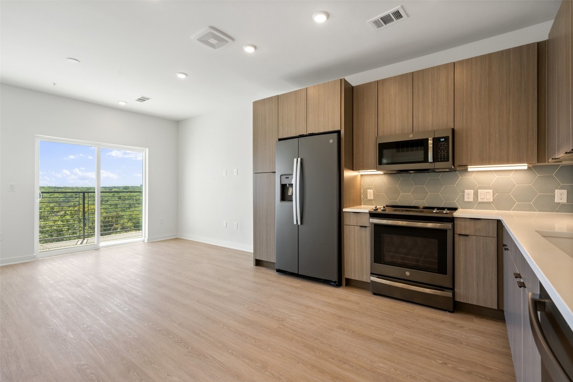 a kitchen with stainless steel appliances a refrigerator and a stove top oven