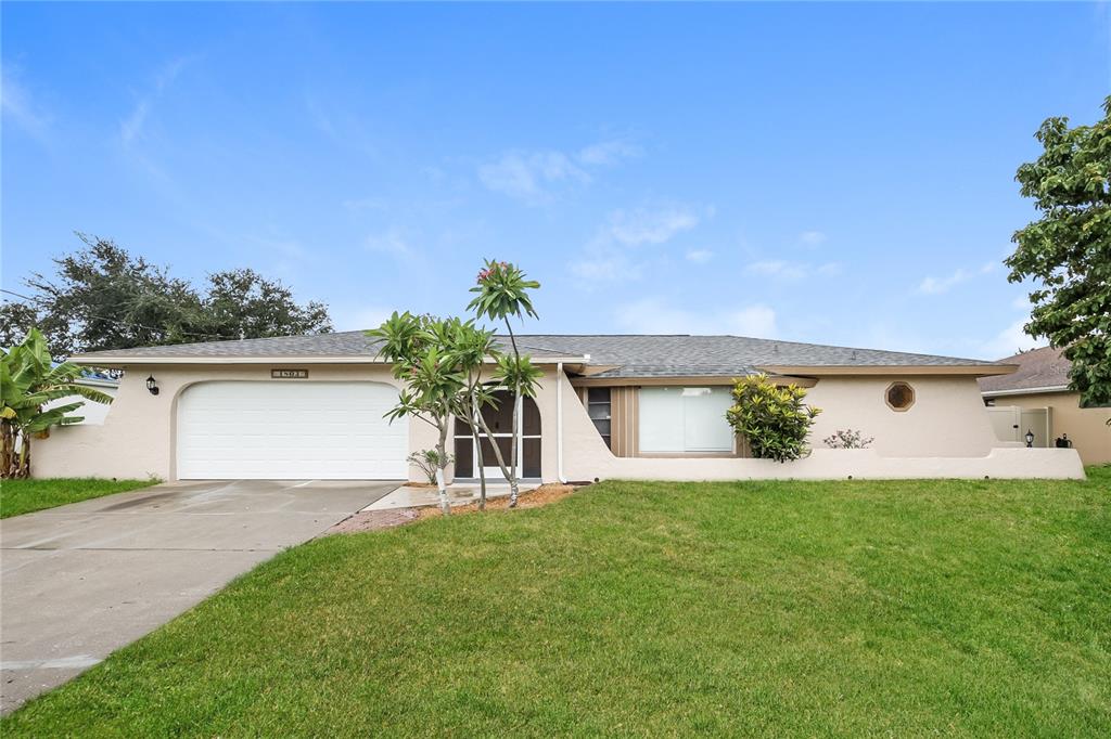 a front view of a house with a yard and a garage