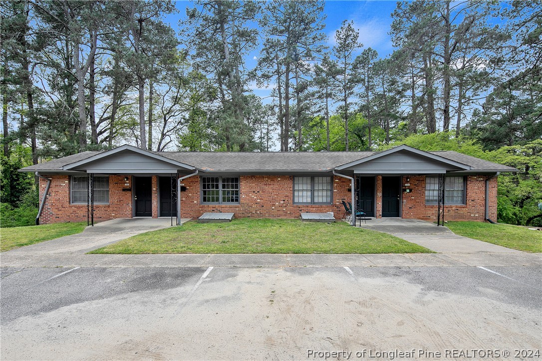 a front view of a house with a yard and trees