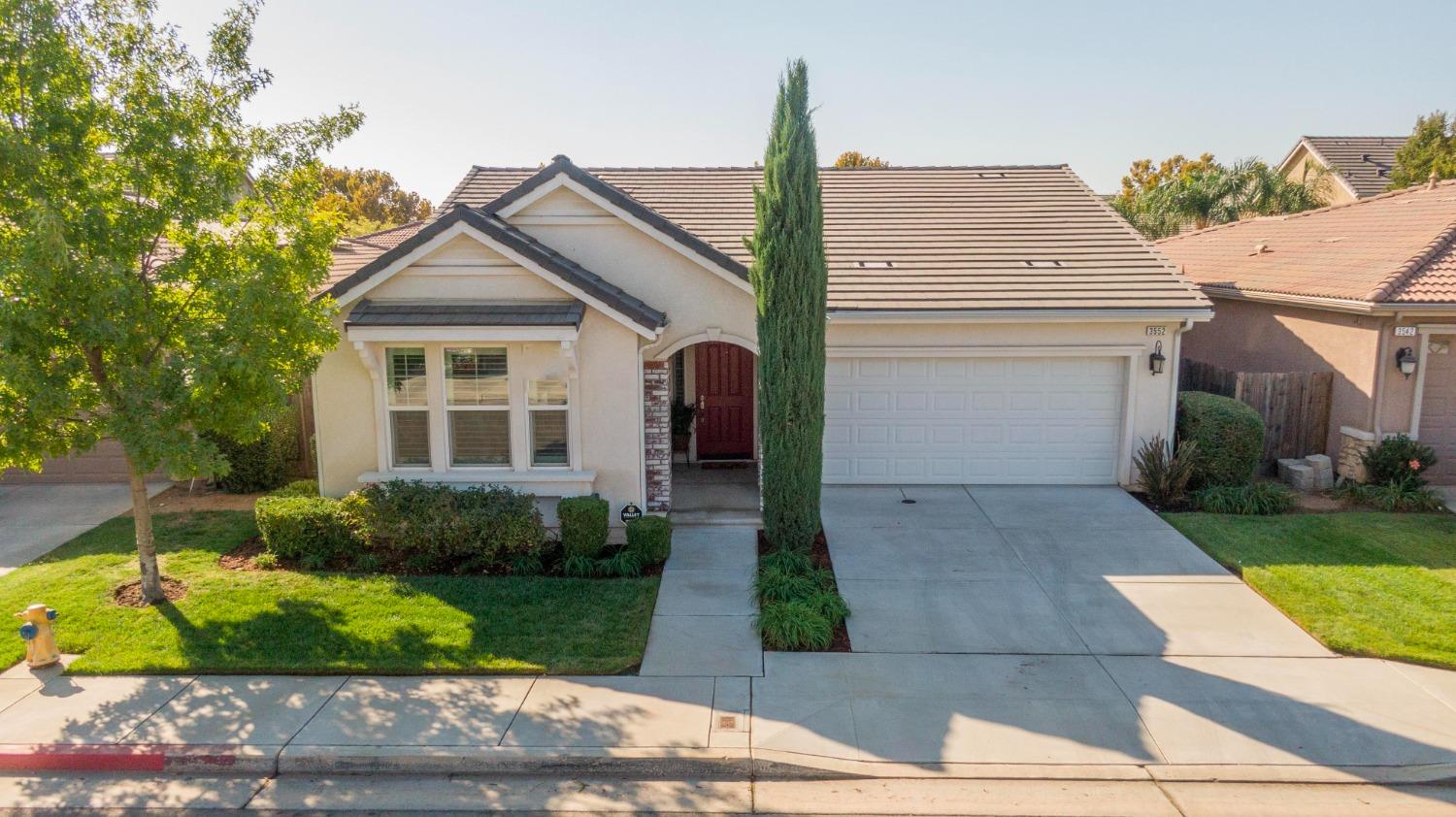 a front view of a house with a yard and trees