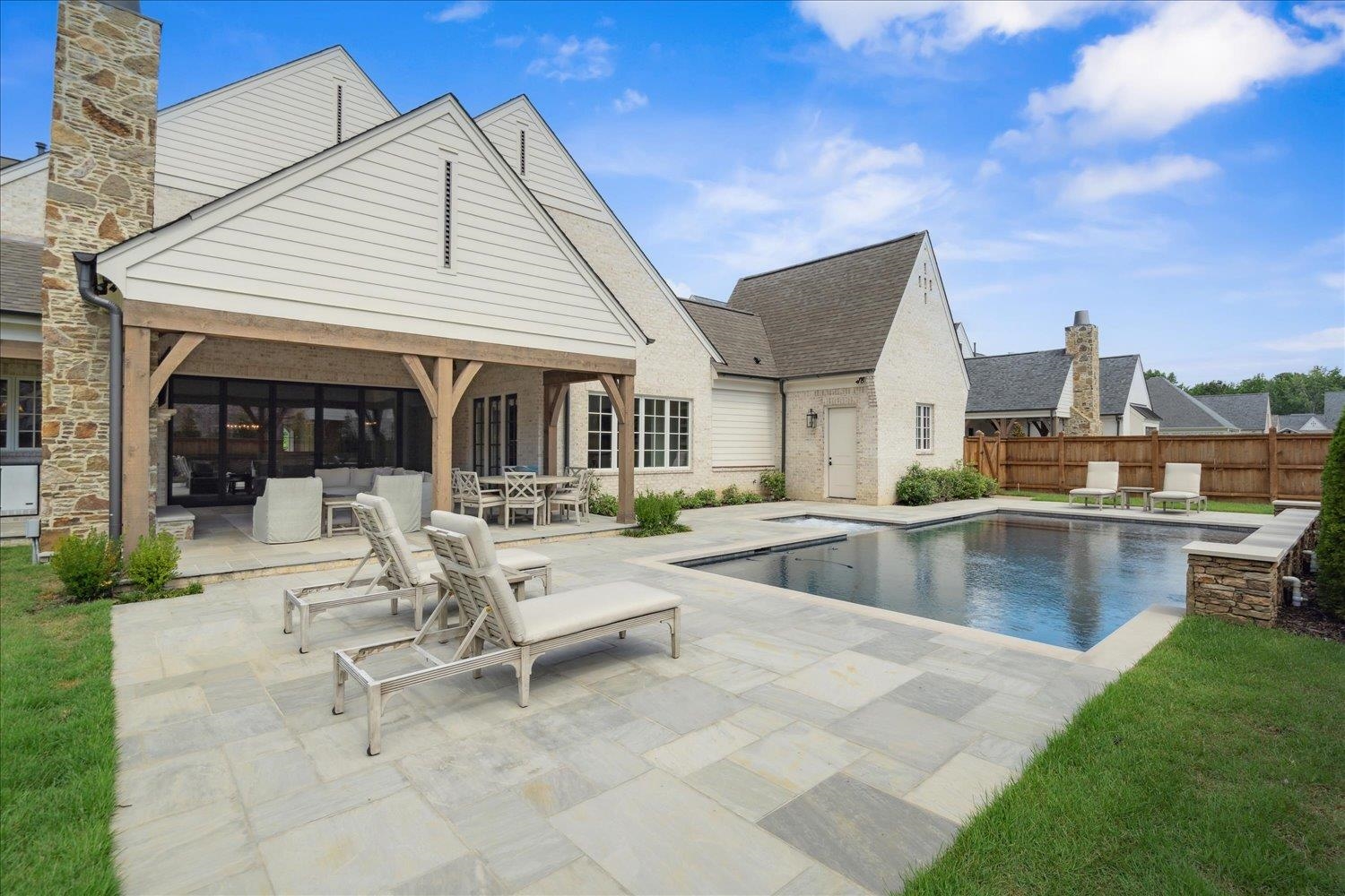 a view of house with swimming pool and sitting area