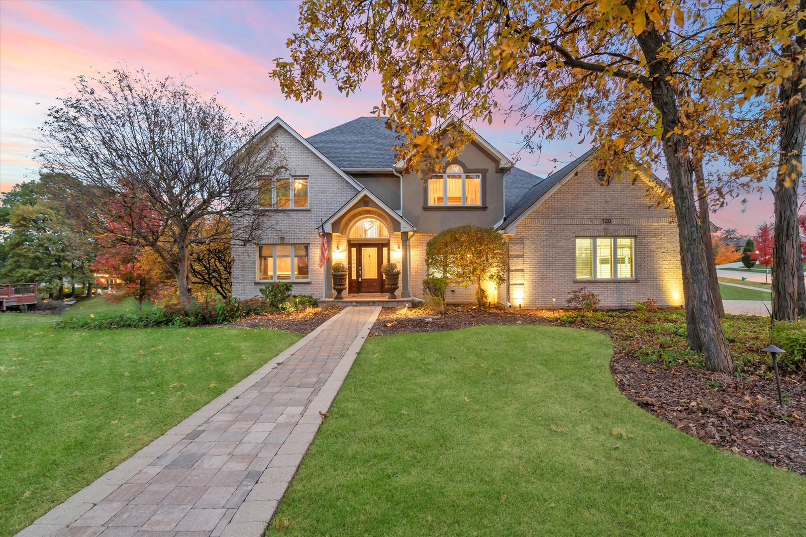 a front view of a house with yard and green space