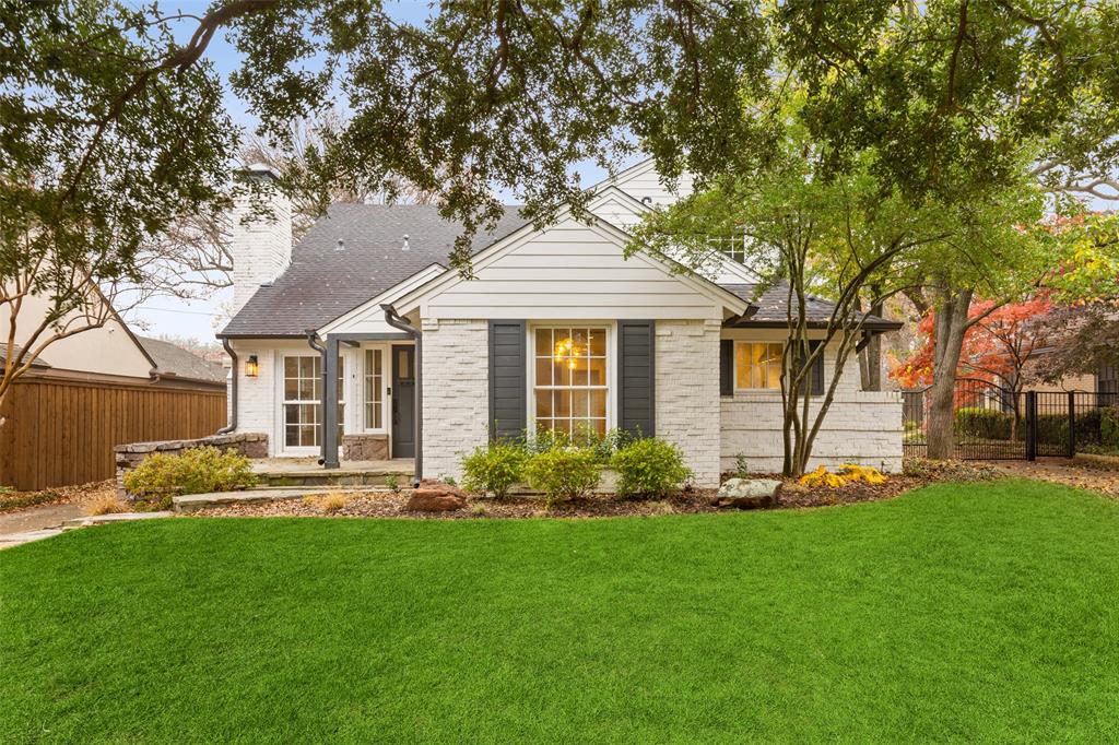 a front view of a house with a yard and trees