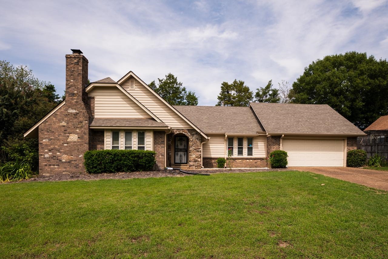 a front view of a house with a garden and yard