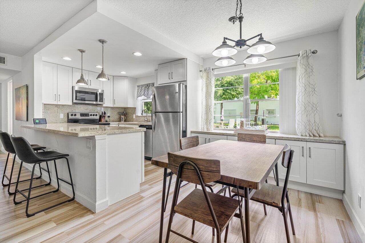 a kitchen with kitchen island a table and chairs in it