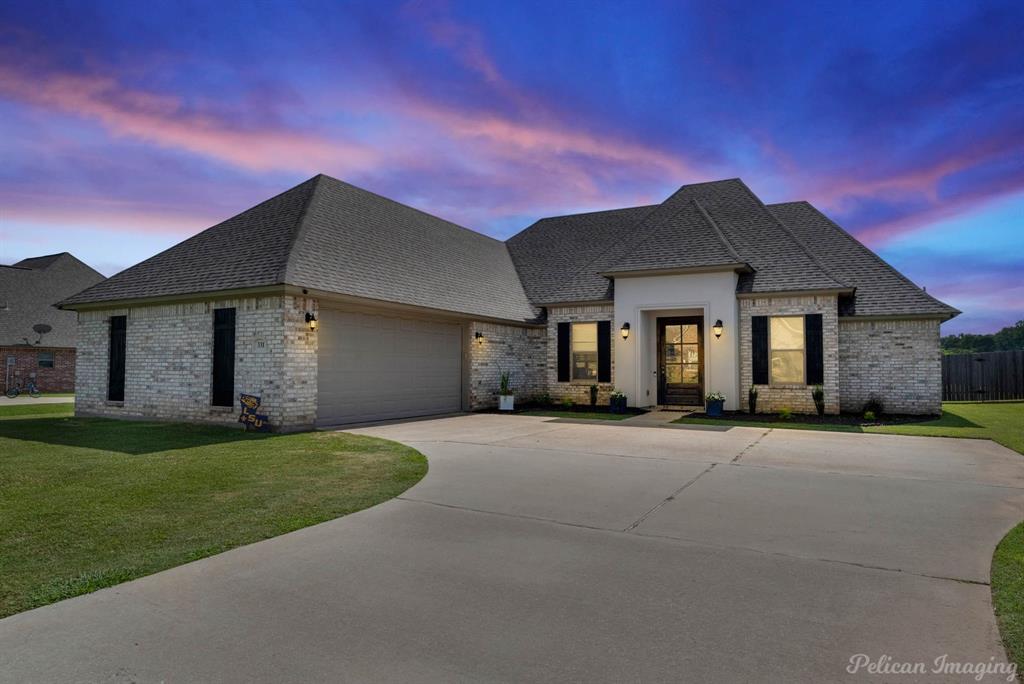 a front view of a house with a yard and garage