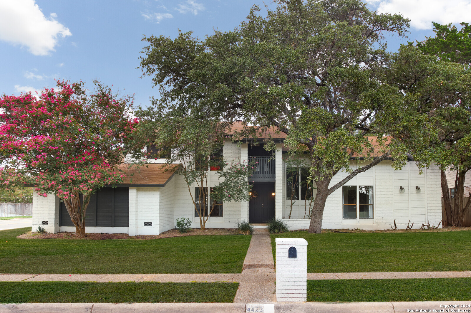 a front view of a house with a garden