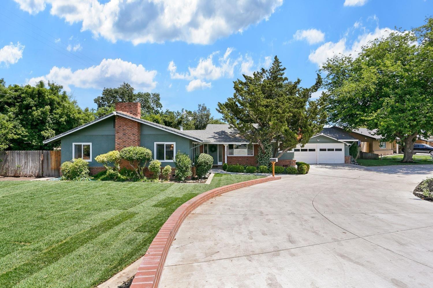 a front view of a house with a yard and trees