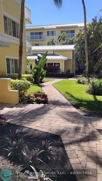 a front view of a house with a yard and potted plants