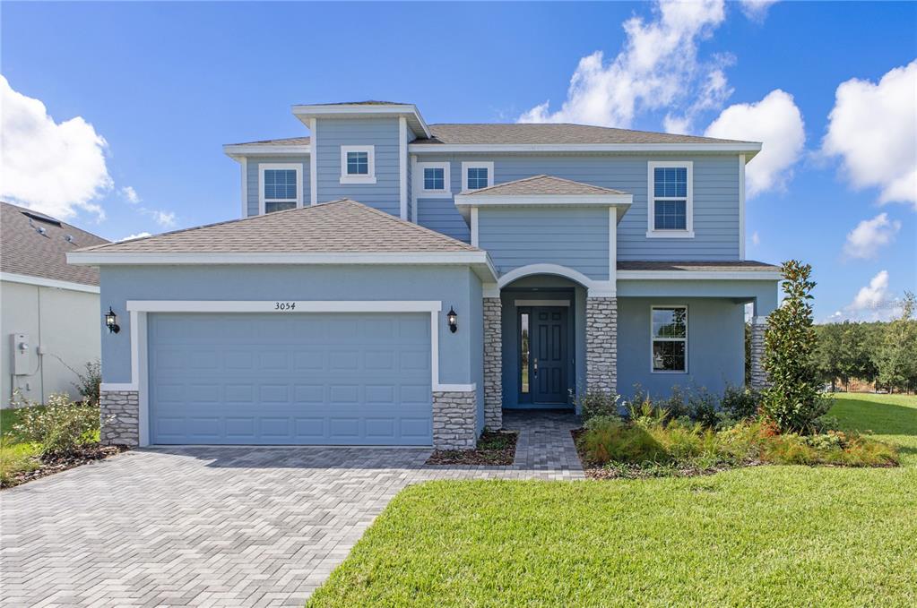 a front view of a house with a yard and garage