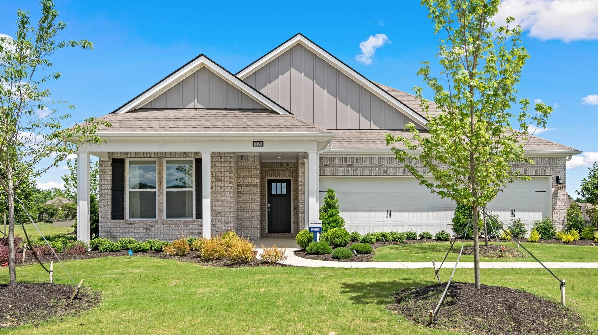 Craftsman inspired home with a garage and a front lawn