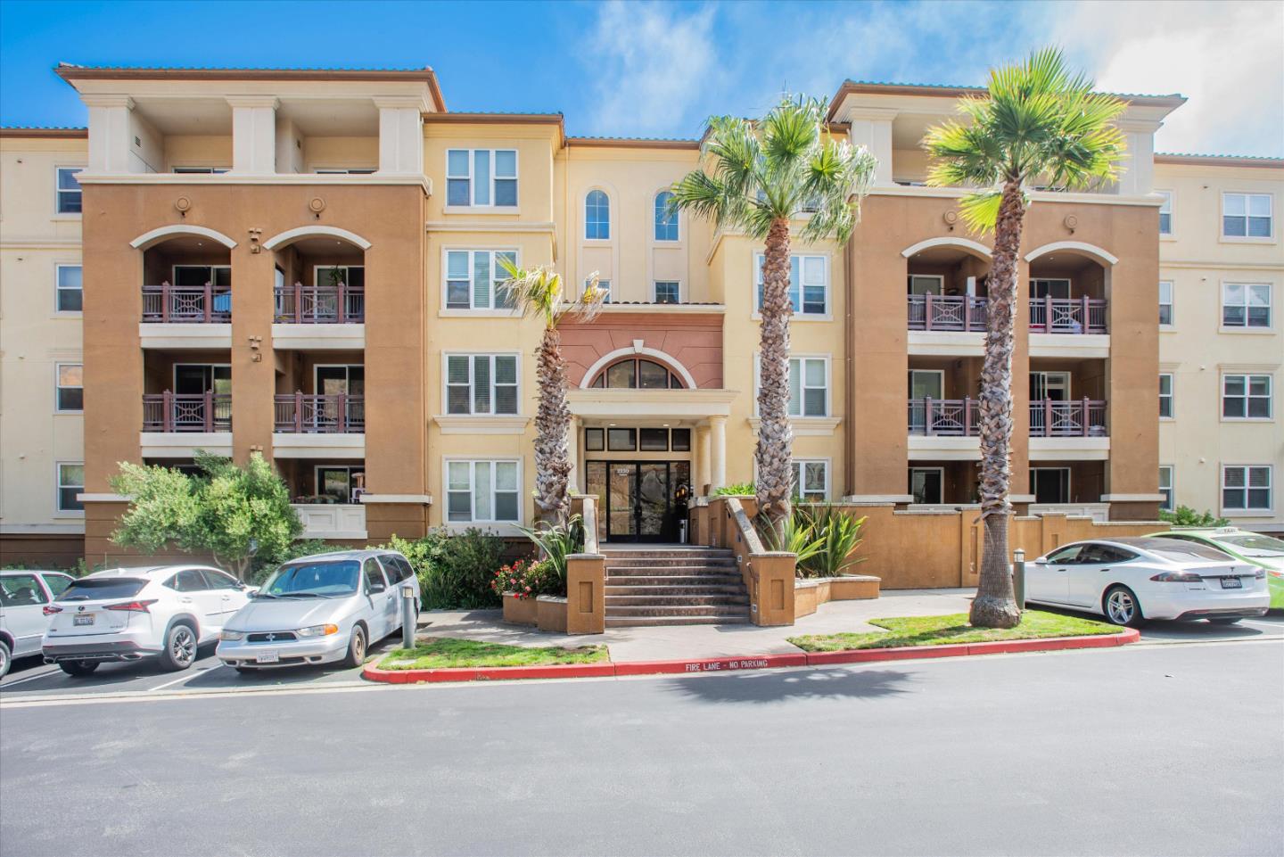 a front view of multi story residential apartment building with yard