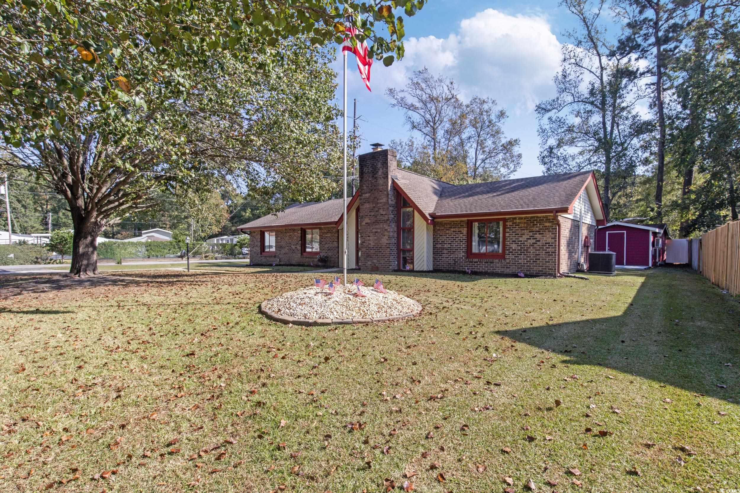 Back of property featuring a shed and a lawn