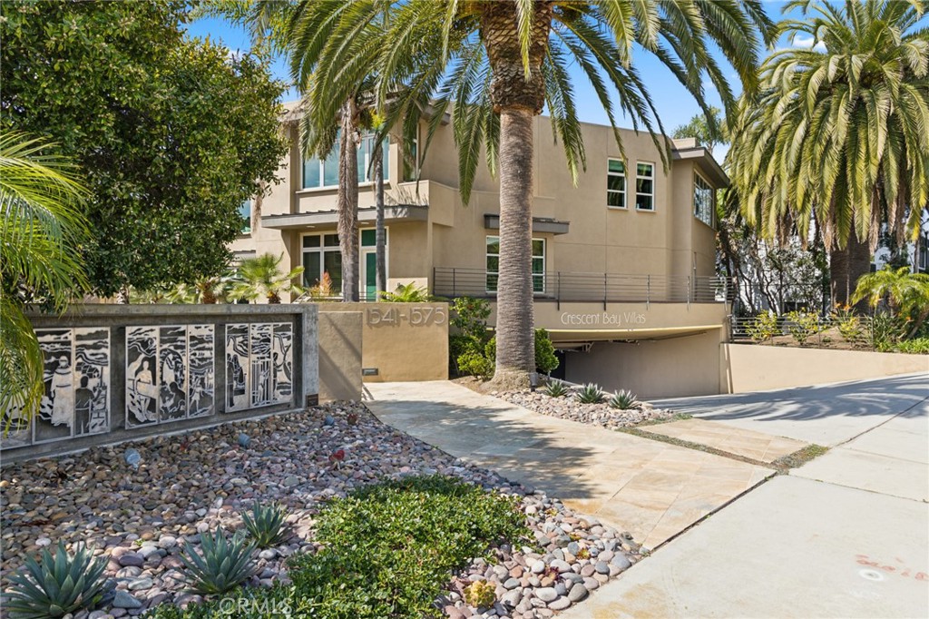 a view of a house with a yard and potted plants