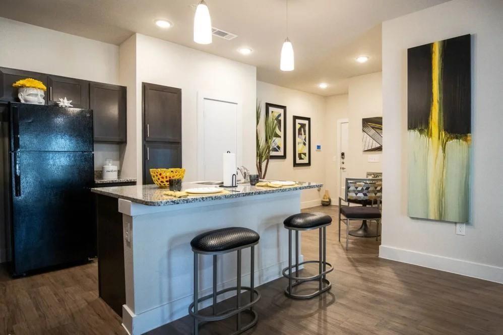 a kitchen with stainless steel appliances granite countertop a sink and a refrigerator