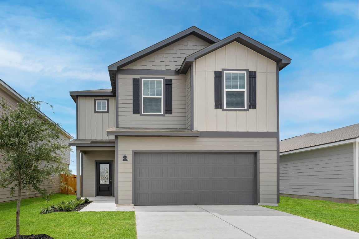 a front view of a house with a yard and garage