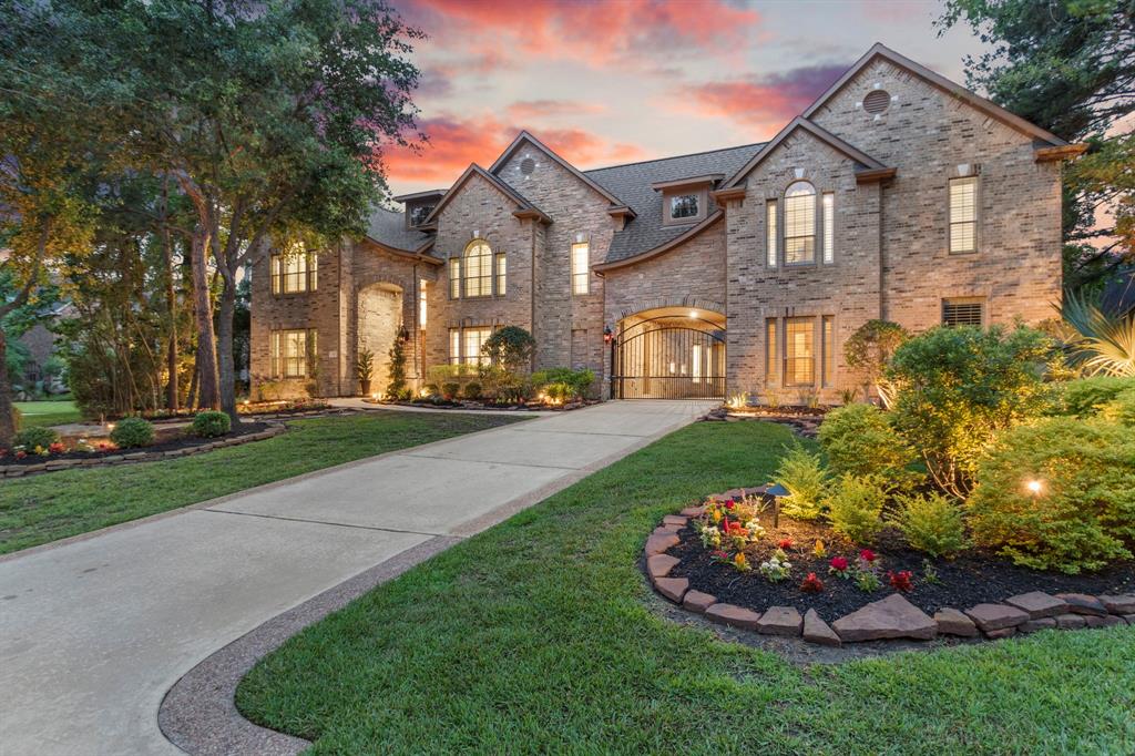 Stunning twilight view of the luxurious two-story home with beautifully landscaped yard and warm ambient lighting.