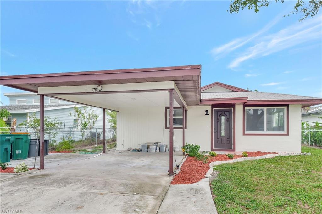 View of front of house with a front yard and a carport