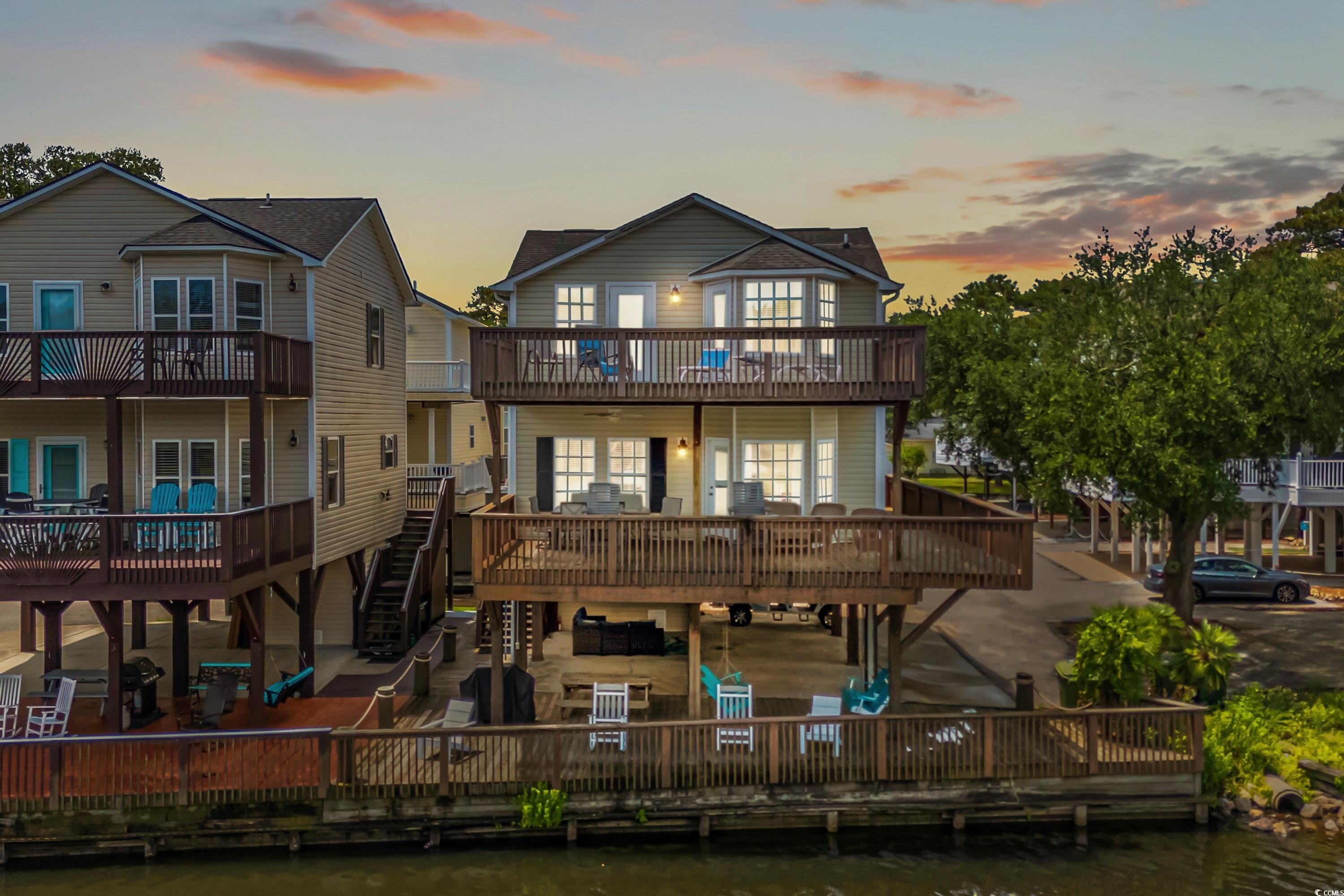 Back house at dusk with a balcony and a wooden dec