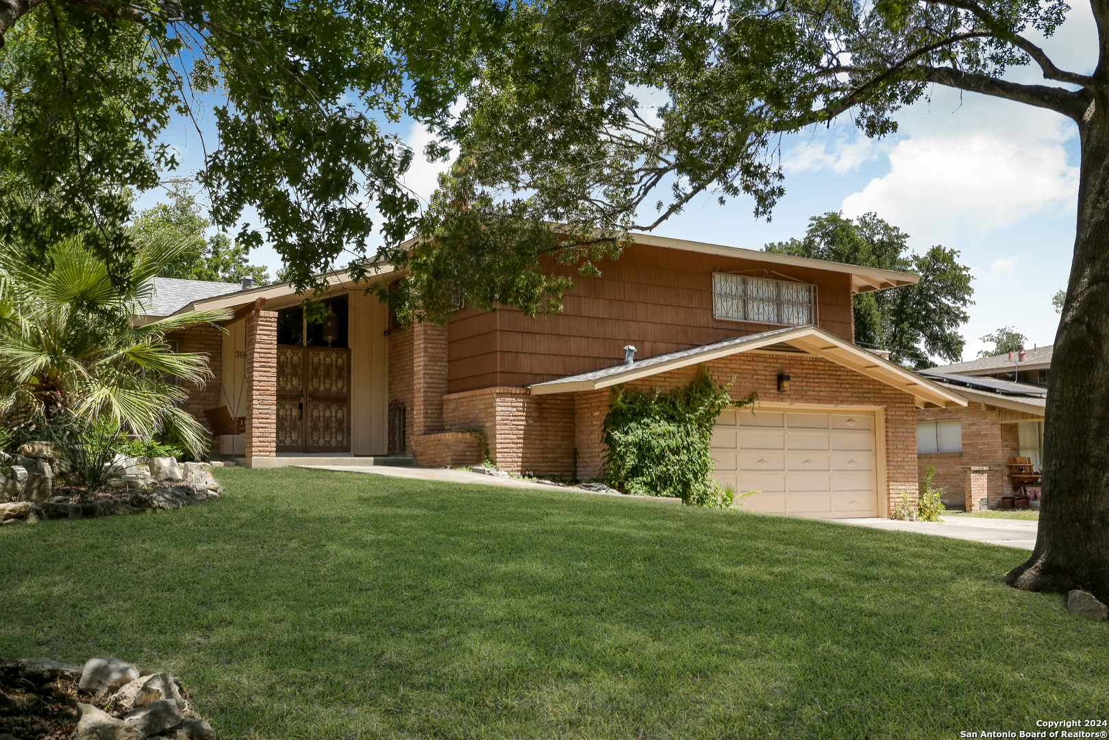 a front view of a house with a garden