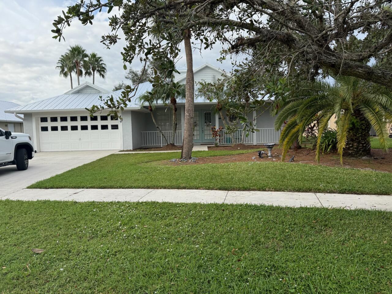 a view of a house with a big yard and large trees