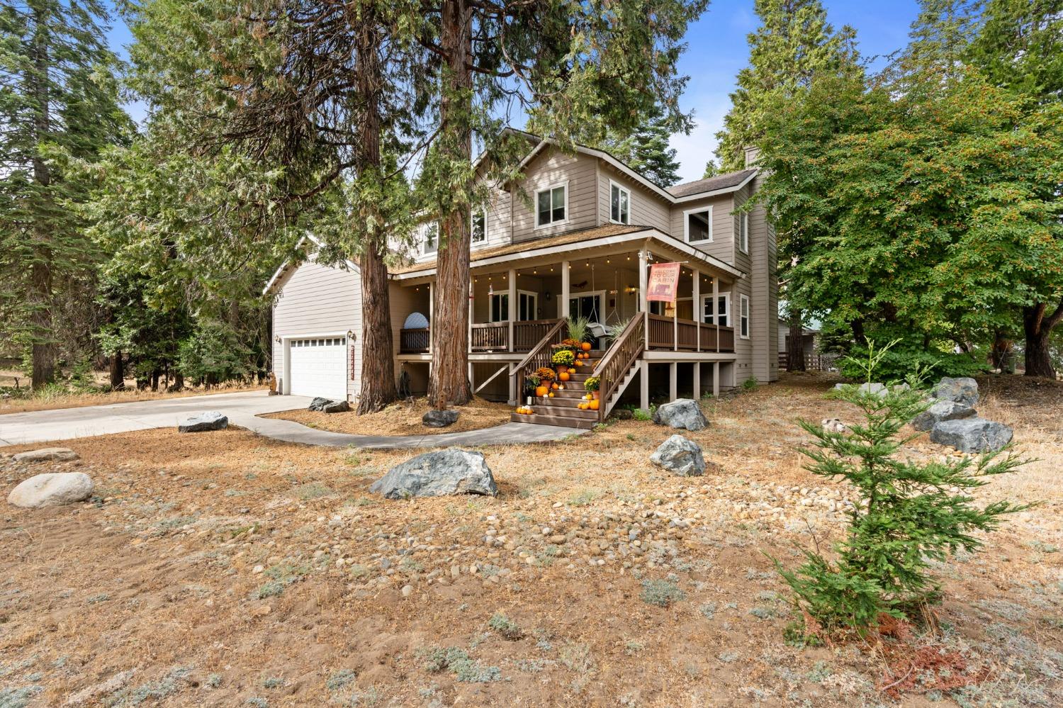 a view of a house with backyard and tree