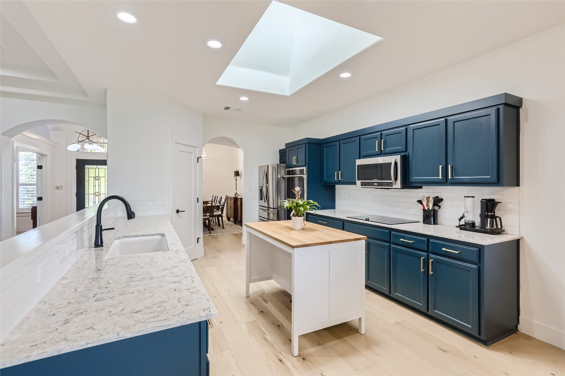 a kitchen with sink a microwave and cabinets