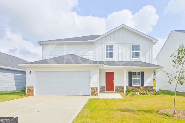 a front view of a house with a yard outdoor seating and garage