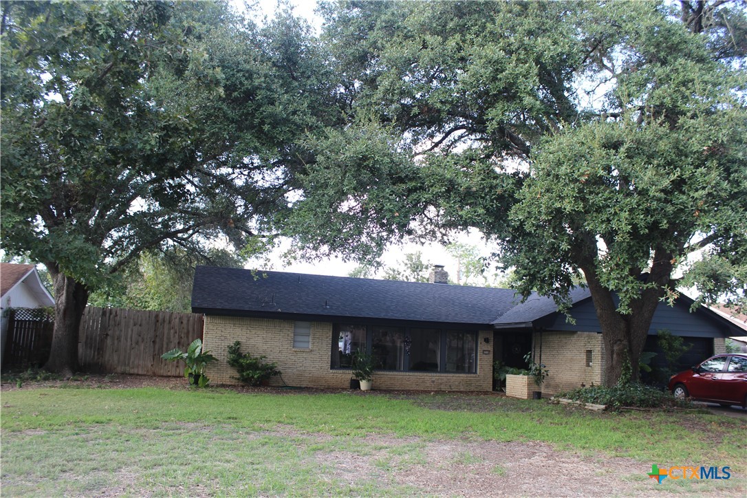 a front view of a house with a garden and trees