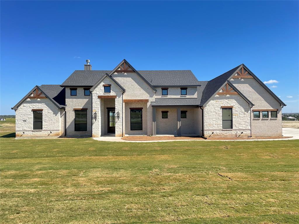 a white house with a big yard and wooden fence