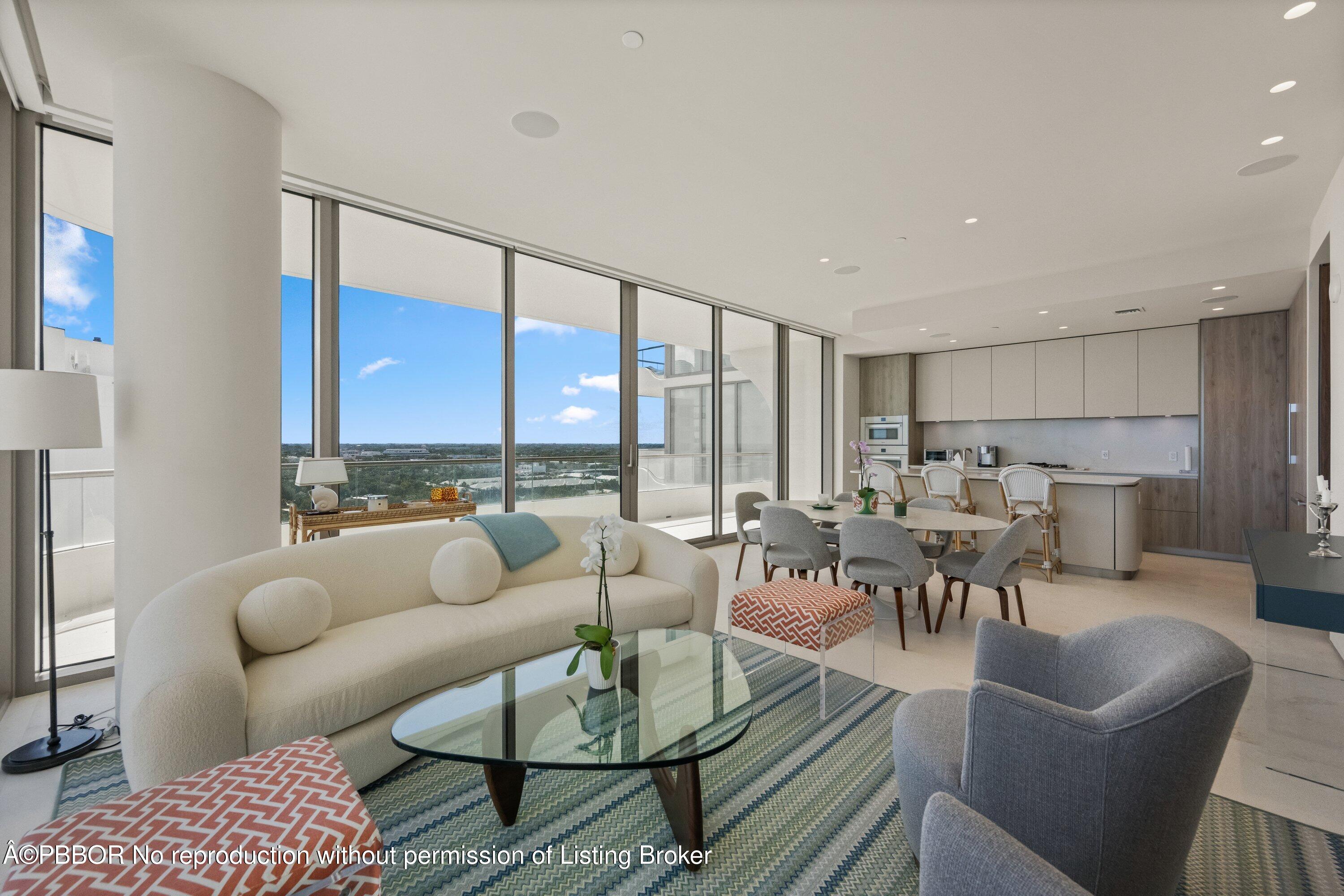 a living room with furniture kitchen view and a large window