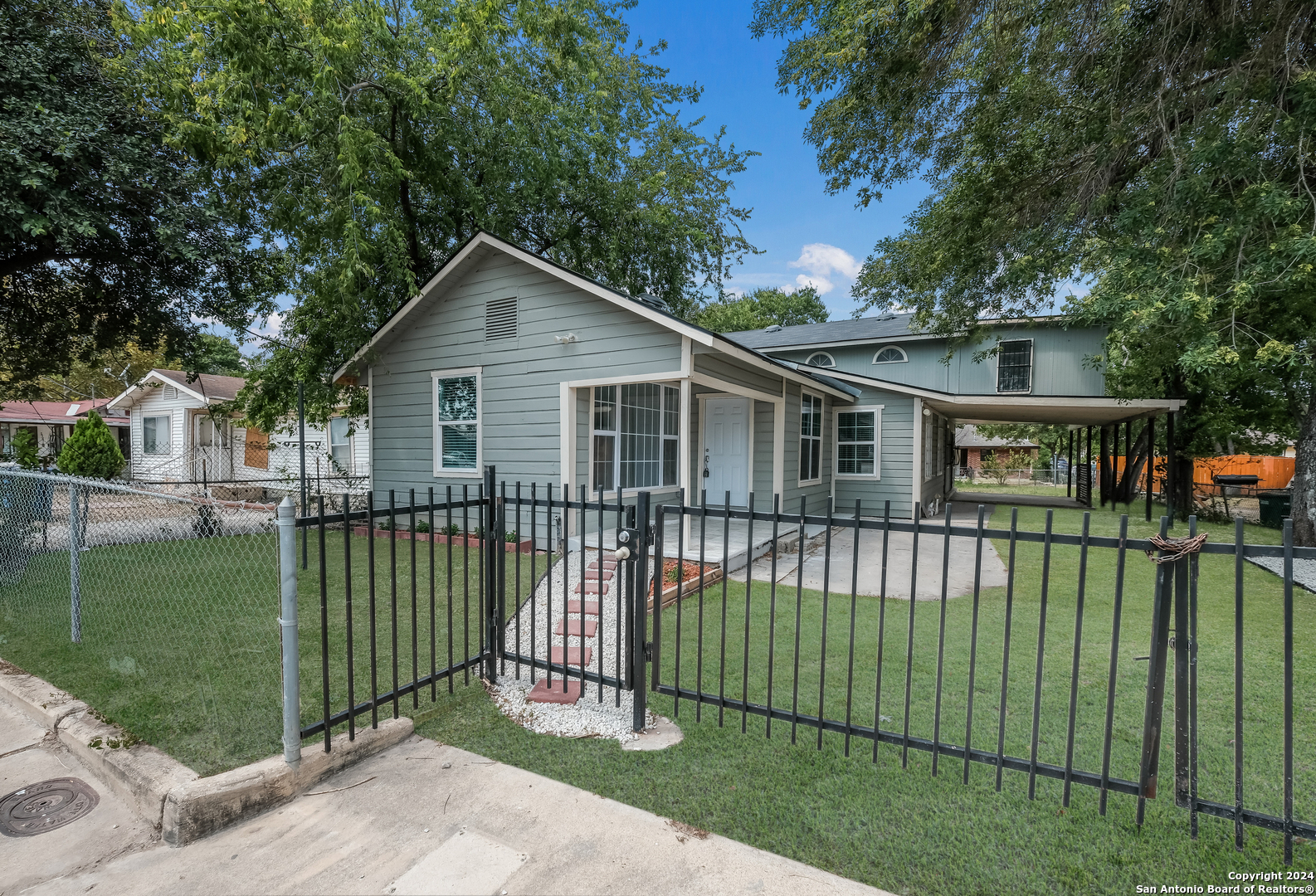 a view of a house with a wooden deck and a yard