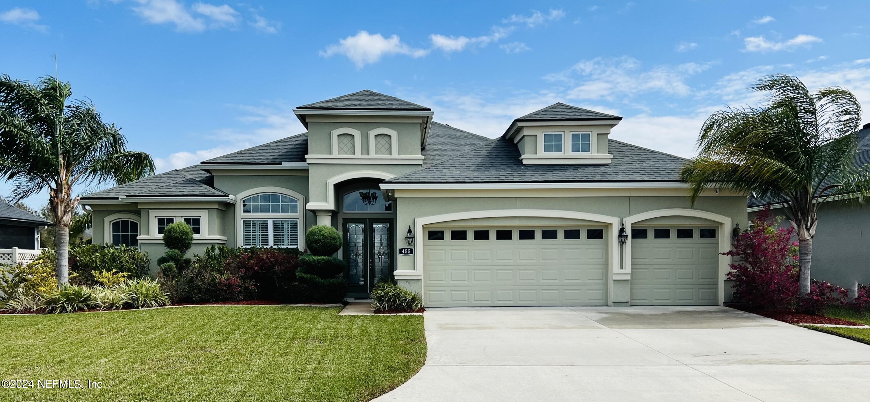 a front view of a house with a yard and garage