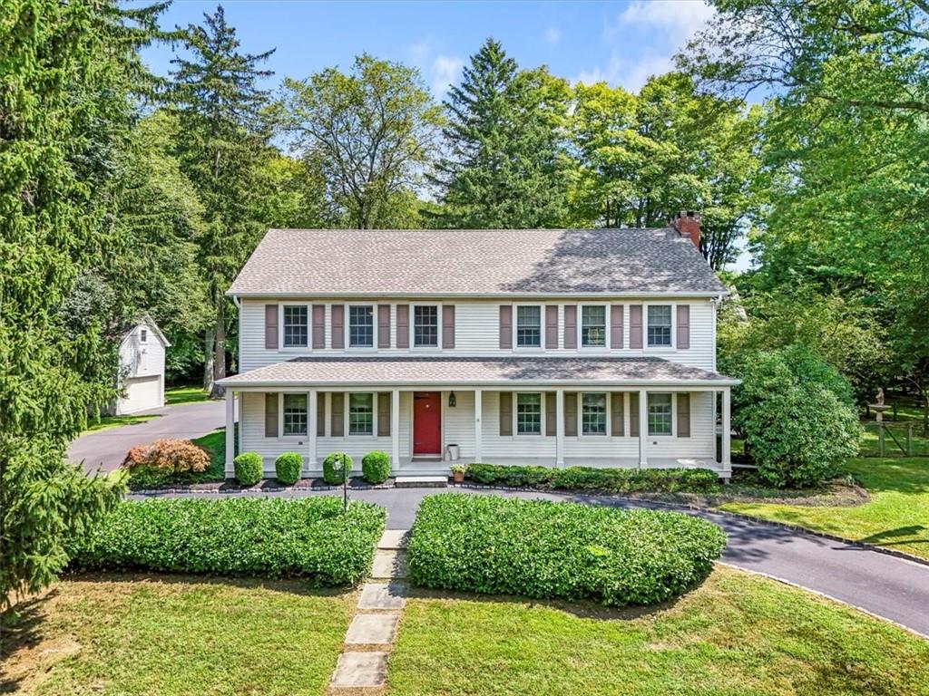 a front view of a house with a yard and potted plants