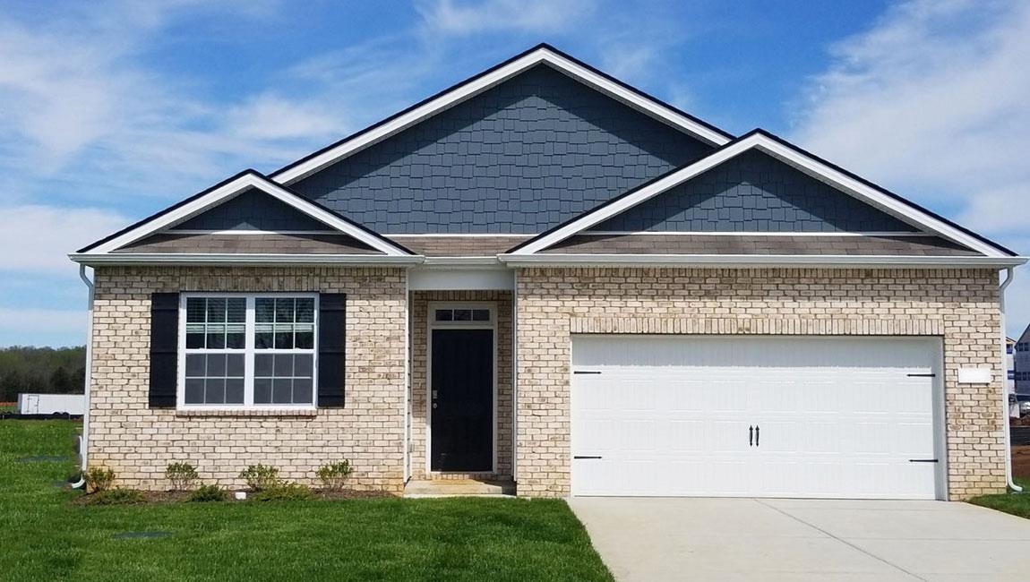 View of front of house featuring a garage and a front lawn