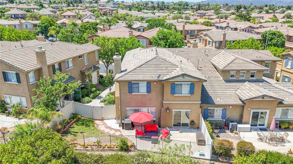 an aerial view of residential houses with outdoor space and trees