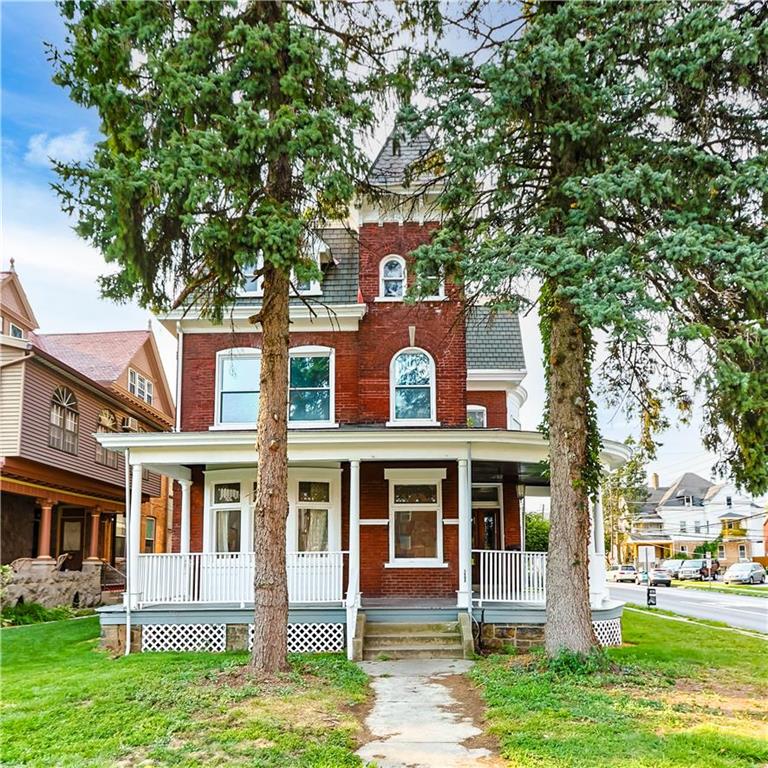 front view of a brick house with a yard