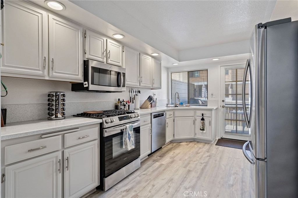 a kitchen with stainless steel appliances granite countertop a stove a sink and a refrigerator